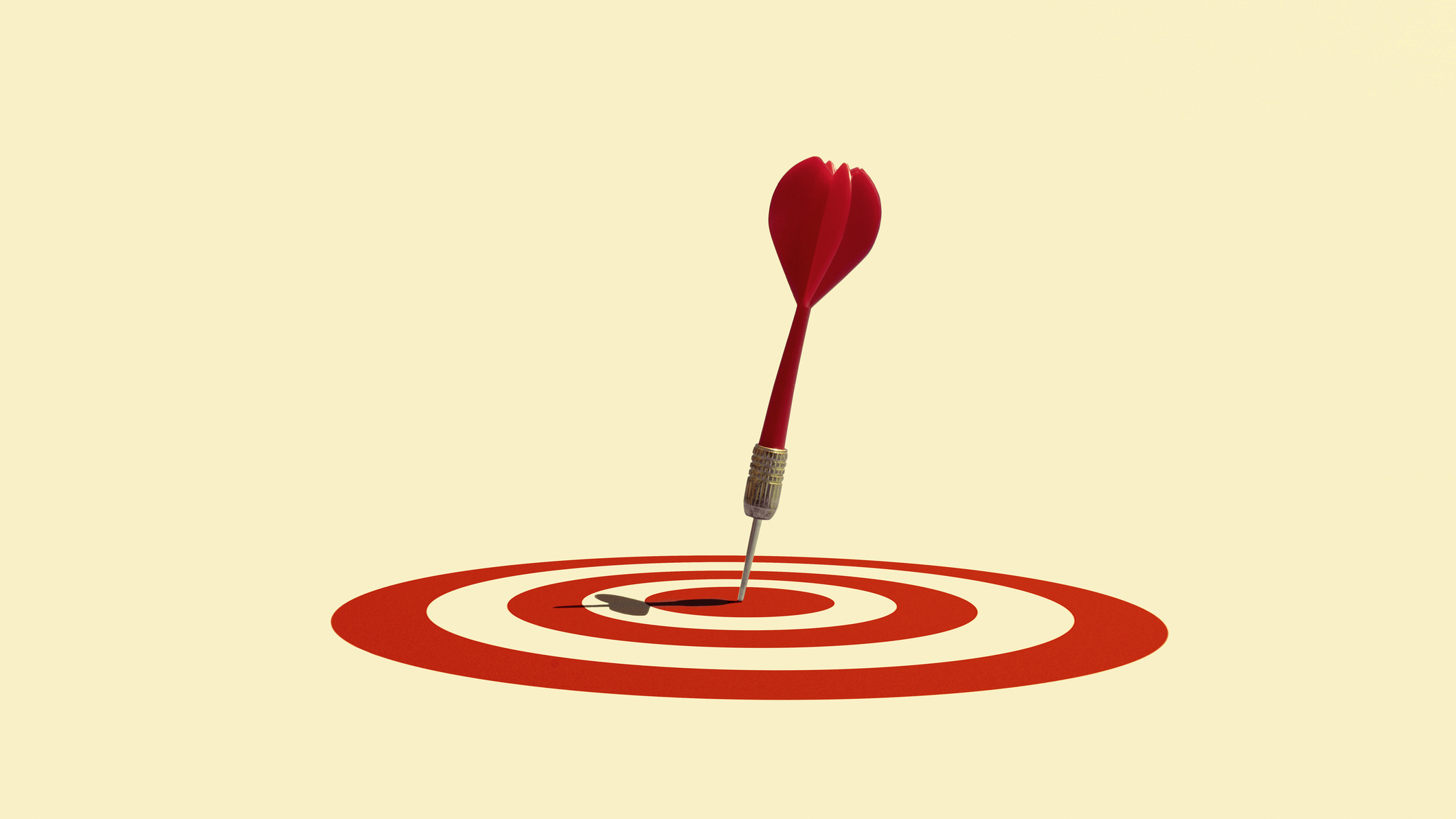 Anak panah yang telah mendarat di tengah bullseye di target merah